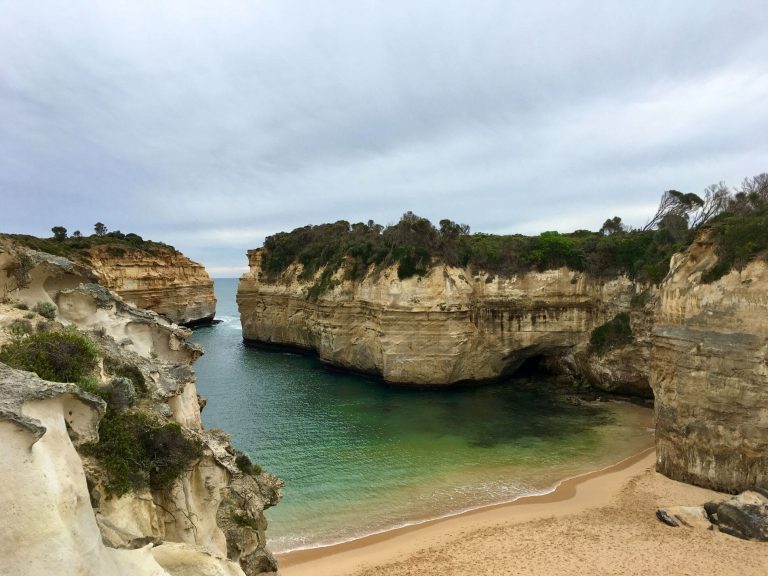 Dramatic coastal cliffs surrounding a secluded beach cove in Australia
