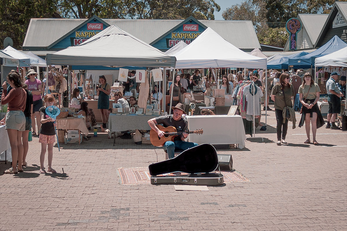 Bustling Margaret River Farmers' Market with stalls and a musician