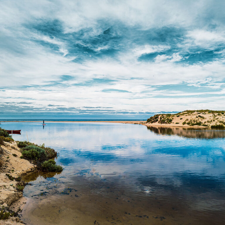 Serene lagoon with reflective waters and sand dunes in Margaret River
