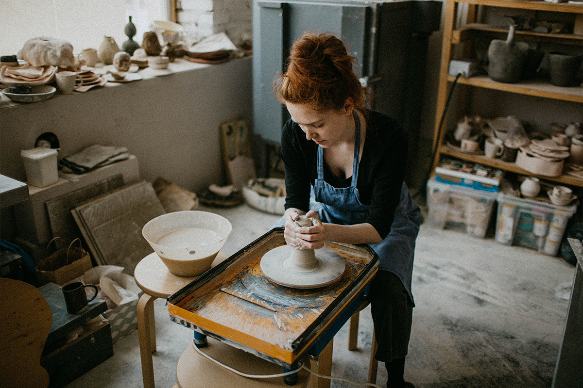 Artist creating pottery on a wheel in a studio workshop