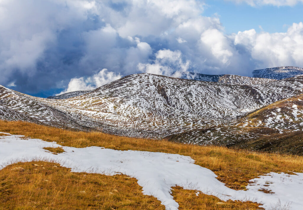 patches-of-snow-building-up-on-slopes-of-snowy-mountains
